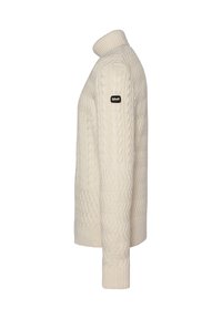 Suéter de punto color crema con un cuello alto, que presenta un patrón de cable texturizado y un parche de logo negro en la parte superior del brazo.