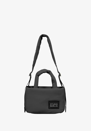 Sivá polstrovaná kabelka s dvojitými uchami a nastaviteľným popruhom, so štítkom s logom na prednej strane. Hladká textúra látky a obdlžnikový tvar.