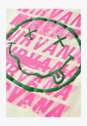 Világos krémszínű anyag, amelyen nagy zöld mosolygós arc mintázat látható, texturált neonzsírpink körvonallal, amelyen átfedésben a „Nirvana” felirat szerepel.