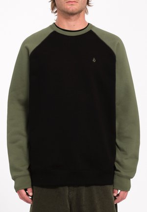 Sweat-shirt noir avec des manches raglan vert olive. Comprend un col et des poignets côtelés. Un petit logo est positionné sur la poitrine. Texture douce.