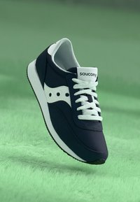 Navy sneaker with white accents, featuring a lace-up design, padded collar, and rubber sole. Saucony logo on tongue. Textured material.
