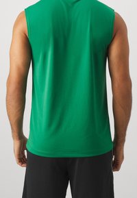 Groen mouwloos shirt gemaakt van zachte stof, met een ronde hals en een losse pasvorm. Effen ontwerp zonder patronen of accenten.