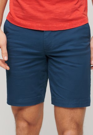 Pantaloni corti blu navy, fino al ginocchio, realizzati in tessuto liscio con fronte piatto, taglio diritto e tasche laterali. Nessun motivo o accessorio visibile.