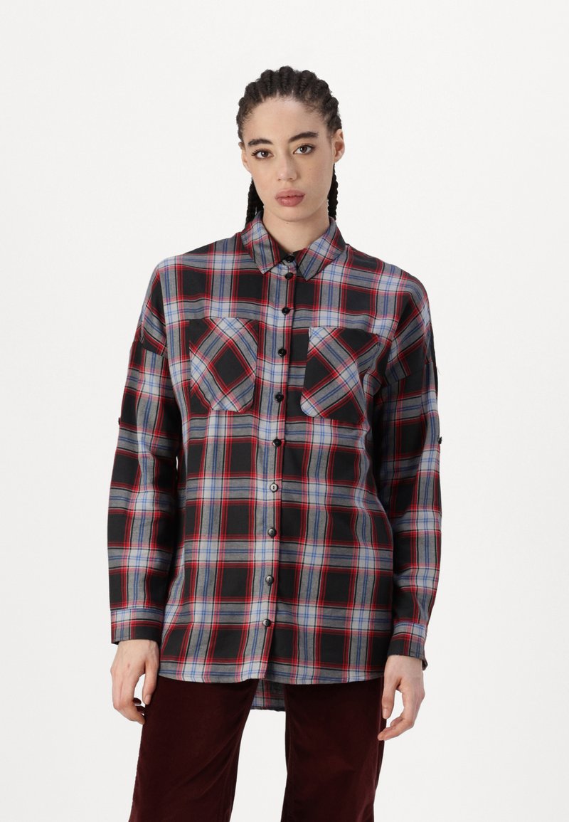 Camicia a quadri rossa, nera e blu con due tasche sul petto, maniche lunghe e orlo dritto, realizzata in tessuto intrecciato.