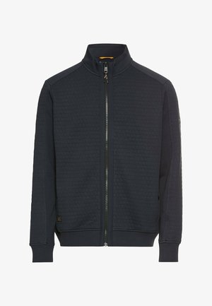 Dunkelblaue Zip-Jacke aus honeycomb-texturiertem Stoff, mit hohem Kragen und gerippten Bündchen sowie kontrastierenden Reißverschlüssen.