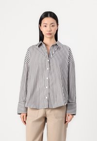 Striped button-up shirt featuring gray and white vertical stripes, a collar, and long sleeves with contrasting striped cuffs.