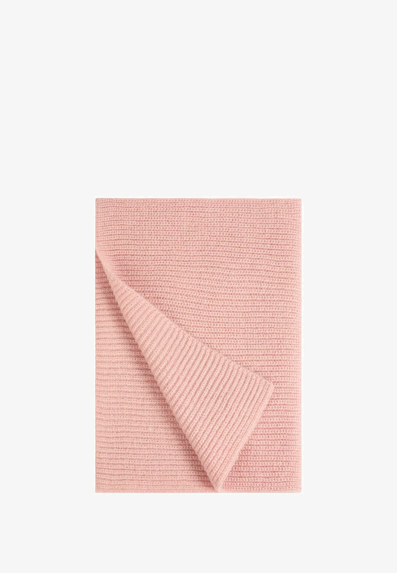 Coperta di cotone di colore rosa chiaro con un design a maglia testurizzata. Un angolo è piegato per rivelare il lato liscio sottostante.