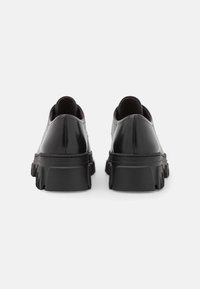 Scarpe in pelle nera con suola spessa nera e design aerodinamico. Finitura liscia e retro arrotondato per un look minimalista.