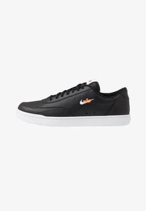 Black leather sneakers with a white rubber sole. Features include black laces, a small Nike logo in white, and a textured upper.