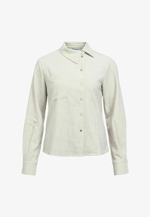 Jasnobeżowa koszula na długi rękaw z guzikami, z ostro zakończonym kołnierzykiem i subtelną kieszonką na piersi, na białym tle.