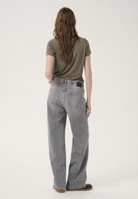 Gray wide-leg jeans with a faded finish, featuring a back pocket design and a rectangular black label on the waistband.