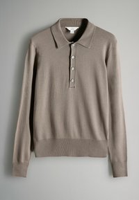 Beživi polo sv sweater s dugim rukavima, rebrastim ovratnikom, plaketom s pet dugmadi i rebrastim rubom. Tkanina djeluje mekano i glatko.