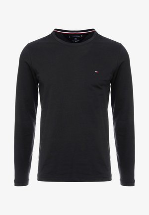 Czarny longsleeve z miękkiej bawełny, z okrągłym dekoltem i małym logo w kolorach czerwonym, białym i niebieskim na klatce piersiowej.