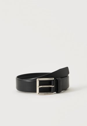 Ceinture en cuir noir avec boucle rectangulaire argentée, roulée sur un fond clair uni.