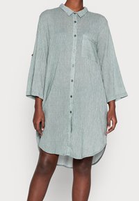 Hellgrünes Hemdblusenkleid mit Kragen, kurzen Ärmeln, einer einzelnen Brusttasche und vertikal gestreiftem Muster.