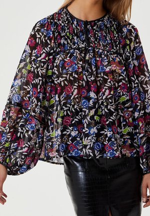 Zwarte doorschijnende blouse met meerkleurig bloemenpatroon, gerimpelde inzetstuk, knoopsluiting bij de halslijn en volumineuze lange mouwen, gecombineerd met een zwarte, gestructureerde rok.