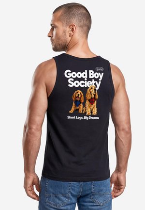Man wearing black tank top with text "Good Boy Society" and two dogs in scarves printed on the back, paired with blue jeans.