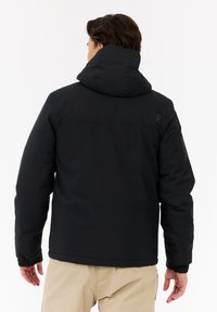 Juodas pūkinis švarkas su gobtuvu, su elastinėmis rankovėmis ir lygia tekstūra. Dizainas apima minimalų ženklą viršutinėje nugaros dalyje.