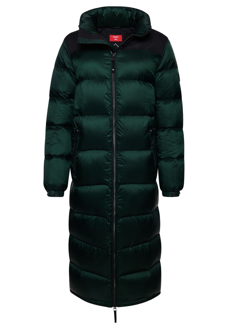 Ciemnozielona kurtka puchowa o długiej sylwetce, błyszczącej fakturze, z zamkiem błyskawicznym z przodu oraz kontrastowymi czarnymi akcentami na ramionach i mankietach.