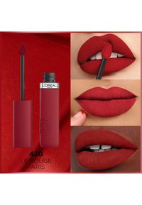 Rouge à lèvres liquide mat rouge dans un tube carré avec un applicateur noir. Des échantillons sur les lèvres montrent différentes carnations. Étiquette : "420 Le Rouge Paris."