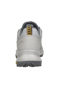 Grijze sportschoenen met een gestructureerde mesh bovenkant, stevige zool en versterkte hiel met een zwart-en-geel trekbandje aan de achterkant.