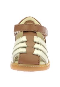 Sandalia de cuero en tonos bronce y dorado con punta abierta, correas entrecruzadas y cierre de gancho y bucle. Suela de goma de color beige claro.