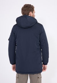 Marineblaue isolierte Jacke mit Kapuze, mit glatter Textur, eng anliegenden Ärmeln und geradem Saum. Verfügt über Seitentaschen und ein minimalistisches Design.