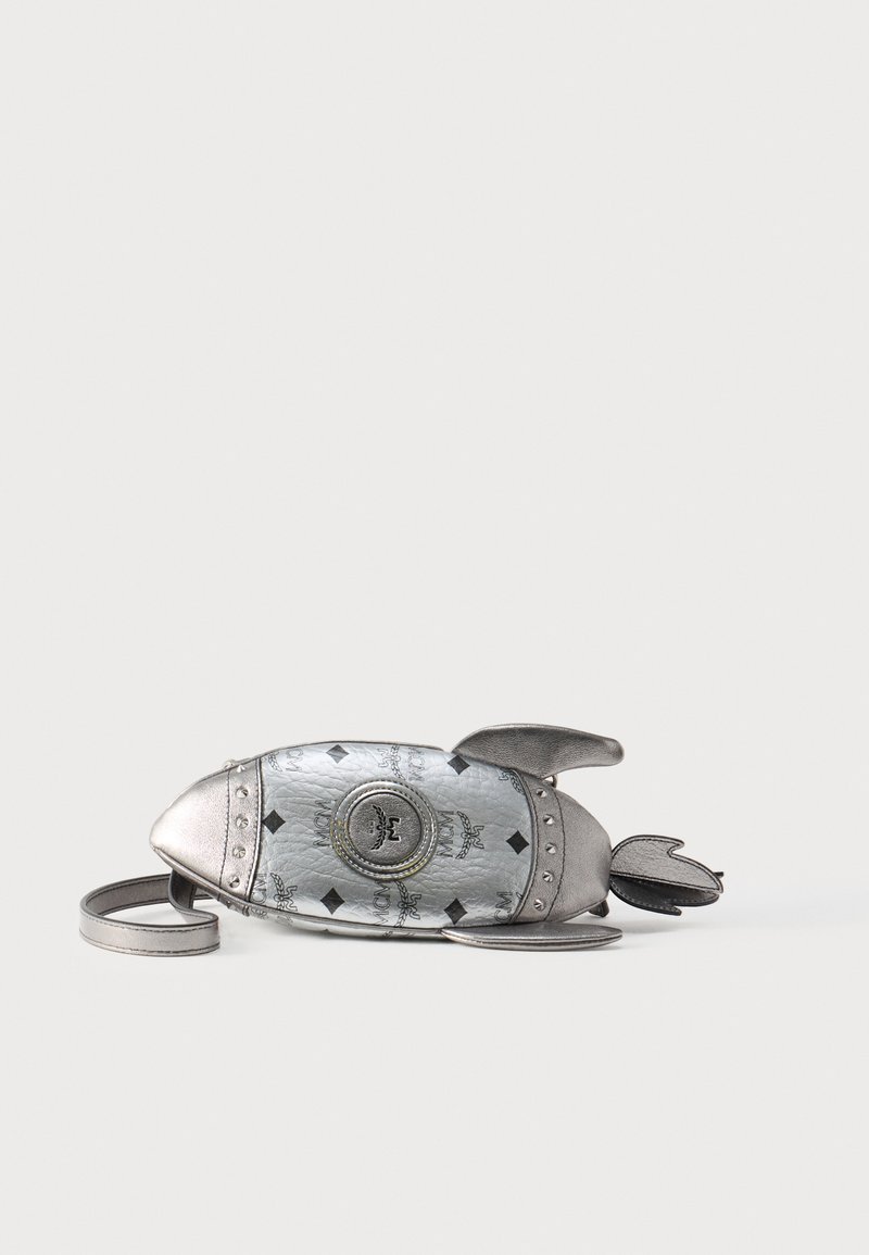 Τσάντα χειρός ασημί σε σχήμα πυραύλου με μαύρο μοτίβο λογότυπου MCM, πτερύγια και αφαιρούμενο λουρί σε απλό λευκό φόντο.