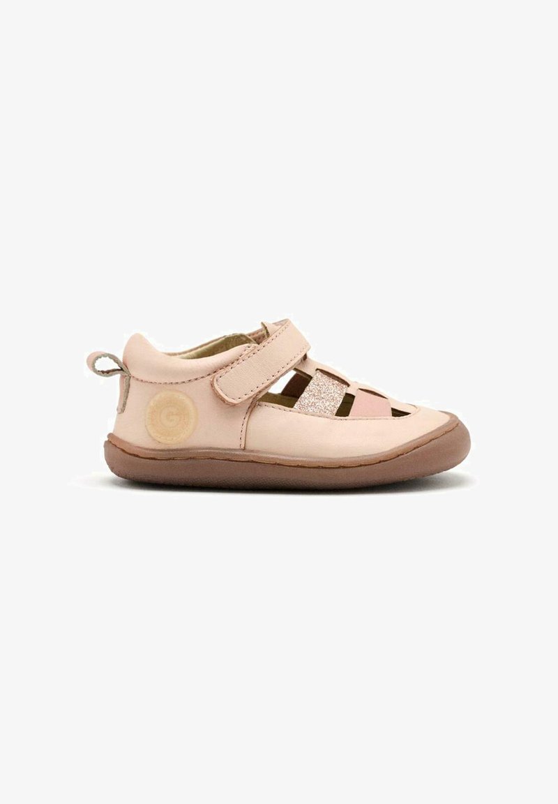 Sandal en cuir rose clair avec design découpé, sangle Velcro ajustable et semelle en caoutchouc beige. Présente un accent texturé sur le côté.