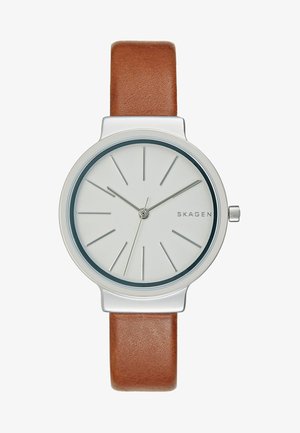 Montre-bracelet argentée minimaliste avec cadran blanc, index des heures et aiguilles argentés fins, bracelet en cuir marron, et nom de la marque "SKAGEN" sur le cadran.