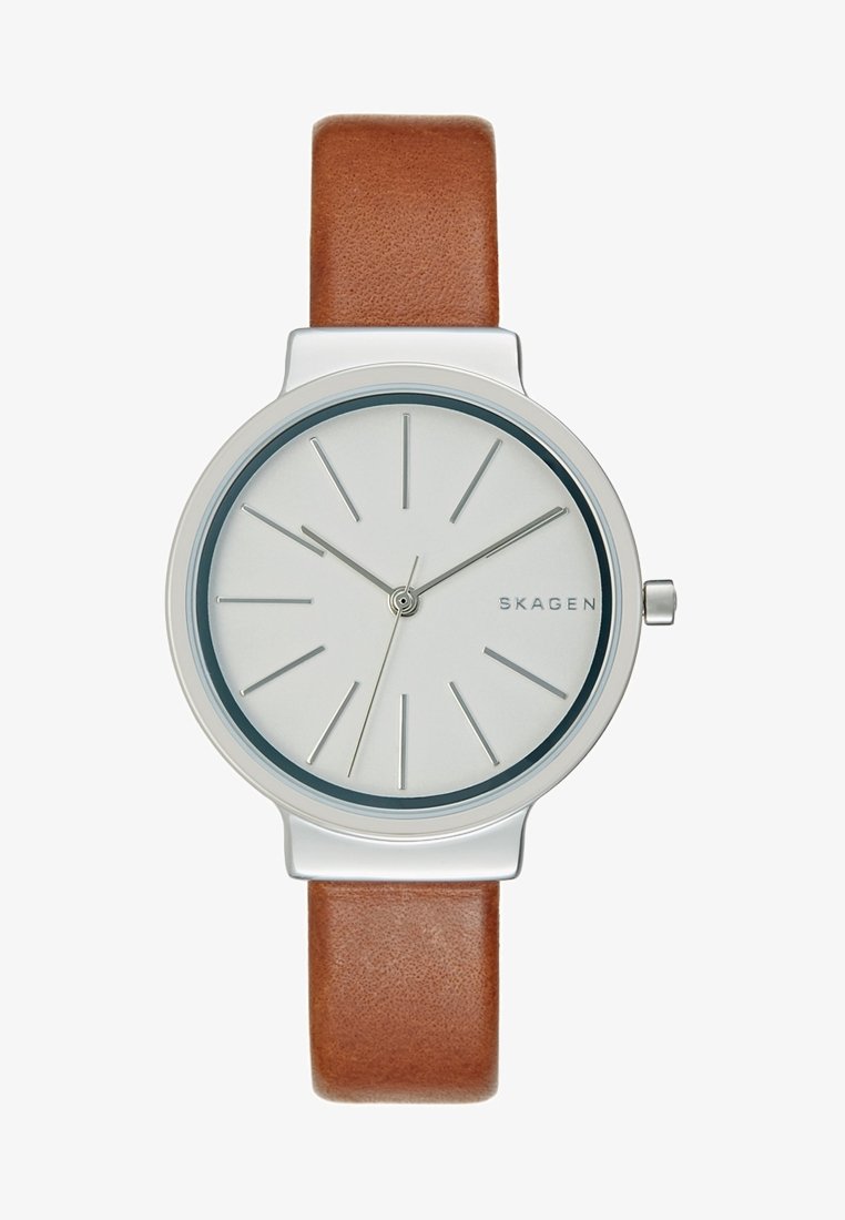 Montre-bracelet argentée minimaliste avec cadran blanc, index des heures et aiguilles argentés fins, bracelet en cuir marron, et nom de la marque "SKAGEN" sur le cadran.