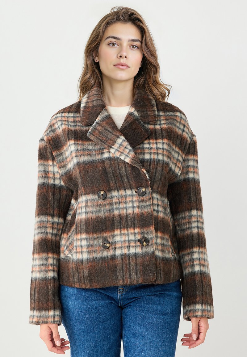 Veste en laine à carreaux marron et blanc avec un design croisé, grand col et deux boutons sur le devant. Vêtement texturé et chaud.