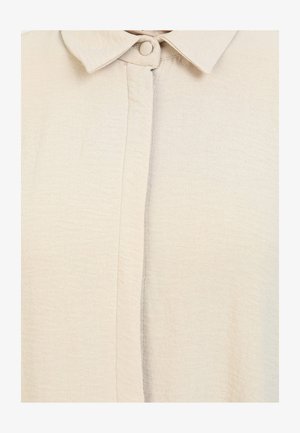 Beige blouse van een gestructureerde, lichte stof, met een klassieke kraag en knoopsluiting aan de voorkant.