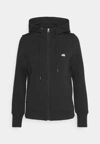 Sweat à capuche noir avec fermeture éclair et cordon de serrage, en tissu doux. Comprend un petit logo blanc sur la poitrine et des poignets côtelés.