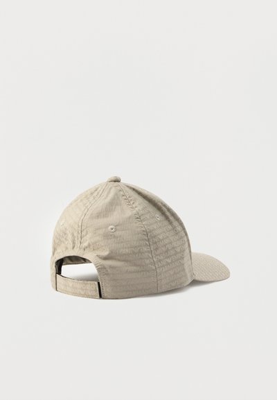 Bēša krāsas beisbola cepure no teksturēta auduma; aizmugurē regulējams siksniņa un izliekta mala. Logotips netraucēti iespiests visā materiālā.