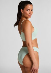 Mintgroene geribde bikiniset met een bralette-top en hoge taillebroekjes, met dunne bandjes en een strakke uitstraling.