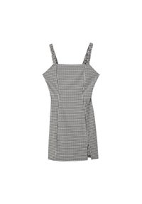 Robe en vichy noir et blanc à fines bretelles, corsage ajusté et fente sur le côté. Fabriquée dans un tissu lisse et léger.