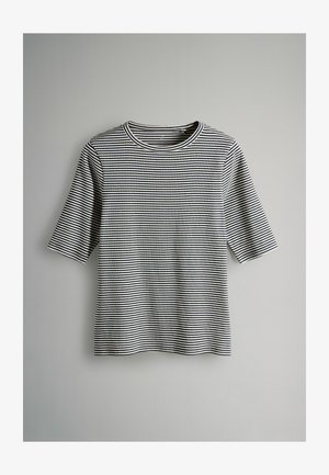 Tricou cu dungi alb-negru, realizat dintr-un material moale. Are gât rotund și mâneci scurte, cu croială lejeră.