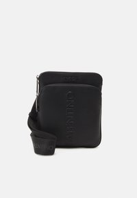 Černá crossbody taška se dvěma zipovými přihrádkami, reliéfní text "VALENTINO" na přední straně a nastavitelný popruh s opakujícím se logem.