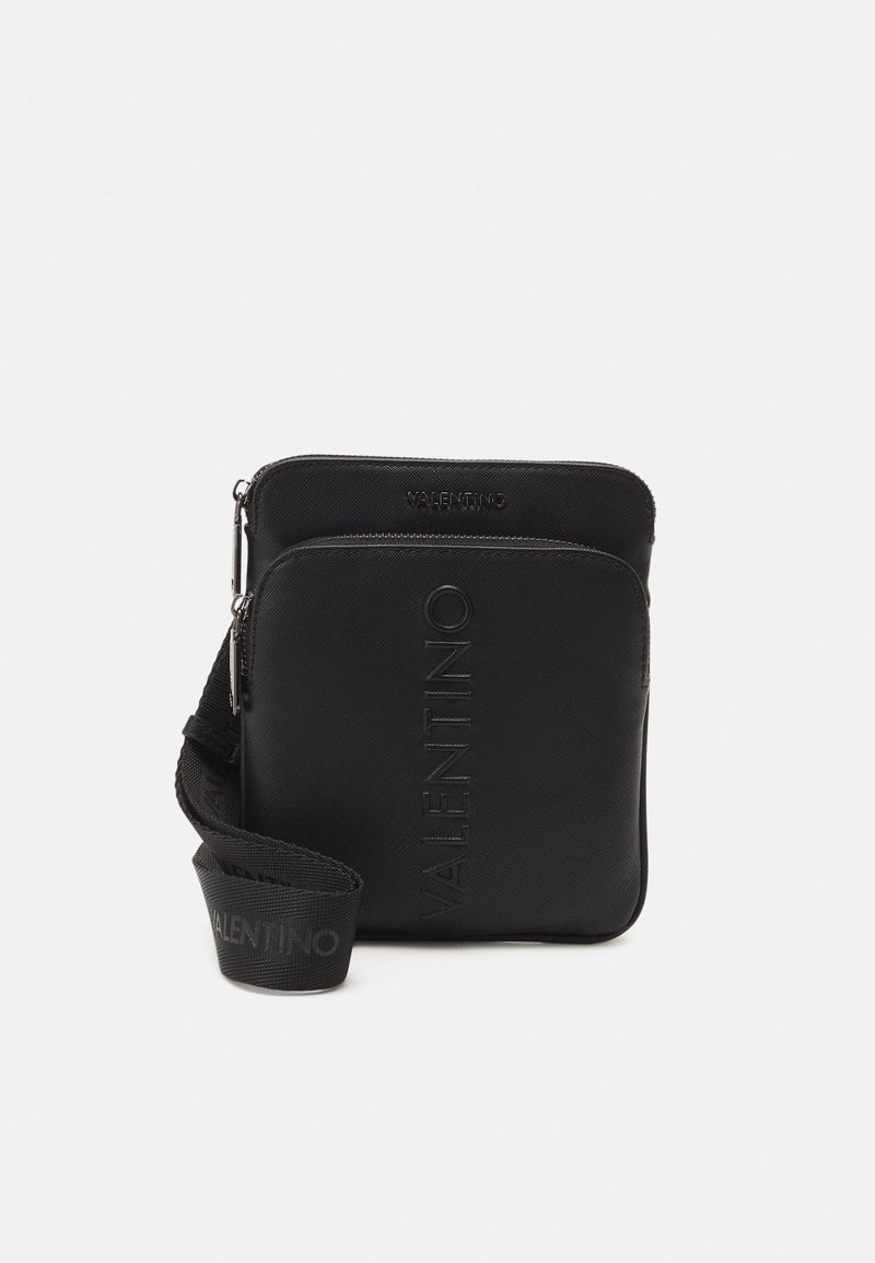 Černá crossbody taška se dvěma zipovými přihrádkami, reliéfní text "VALENTINO" na přední straně a nastavitelný popruh s opakujícím se logem.