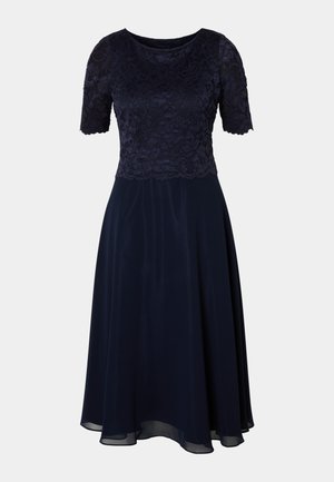 Granatowa sukienka z koronkowym topem, krótkimi rękawami i swobodną spódnicą. Gładka tekstura i długość do kolan z delikatnym połyskiem.