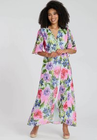 Abito maxi floreale con design avvolgente, maniche corte a campana e tessuto leggero. I colori includono rosa, viola, verde e blu con vari fiori.