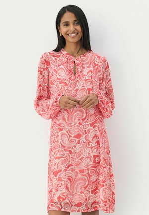 Koraal gekleurde paisley jurk met lange pofmouwen, een keyhole halslijn en geruffelde manchetten. Lichte stof met ingewikkelde witte patronen.