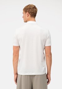 Witte poloshirt met korte mouwen, gestructureerde stof, klassieke kraag en rechte zoom, met een eenvoudige achterkant. Geschikt voor casual draag.