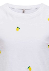 T-shirt en coton blanc avec des broderies de citrons jaunes éparpillés et des feuilles vertes, col rond et manches courtes.