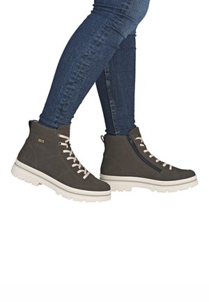 Dunkelgraue High-Top-Stiefel aus glattem Material, ausgestattet mit beigen Schnürsenkeln, einem seitlichen Reißverschluss und einer dicken weißen Sohle mit strukturierter Oberfläche.