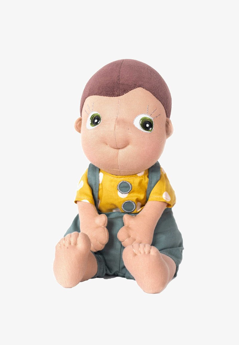 Miś zabawka z beżową twarzą, brązowymi włosami, zielonymi oczami, noszący żółtą koszulę w białe kropki i zielone ogrodniczki.