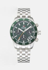 Montre chronographe en acier inoxydable argenté avec un cadran vert, des sous-cadrans noirs, une aiguille des secondes orange et un bracelet en maillons métalliques. Comprend un affichage de la date.