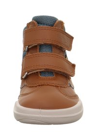 Baskets en cuir marron avec accents en tissu bleu, dotées de deux bandes Velcro réglables et d'une semelle en caoutchouc blanche. Conception à bout arrondi.