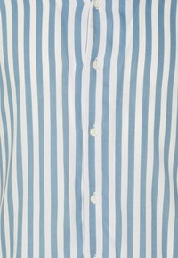 Blau-weiße gestreifte Button-Down-Bluse mit vertikalen Streifen, einer weichen Stoffstruktur und weißen Knöpfen entlang der Vorderseite.